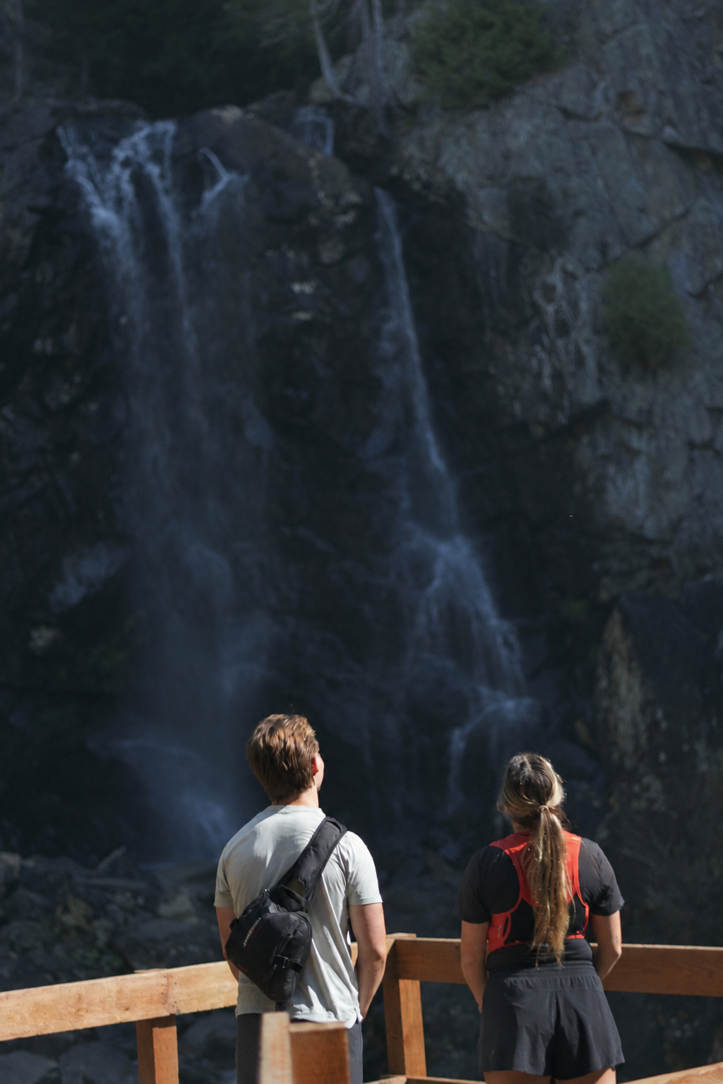 Jade et une autre personne côte à côte devant une chute d’eau.